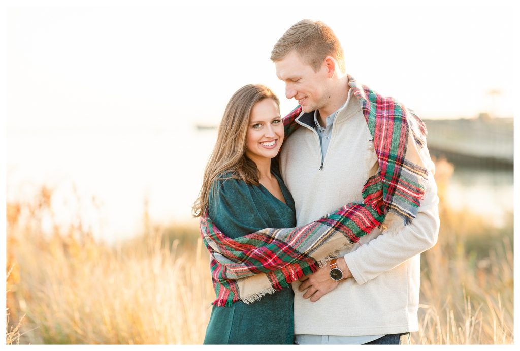 Fall engagement session on the Eastern Shore, Va. Couple wrapped in a plaid scarf.