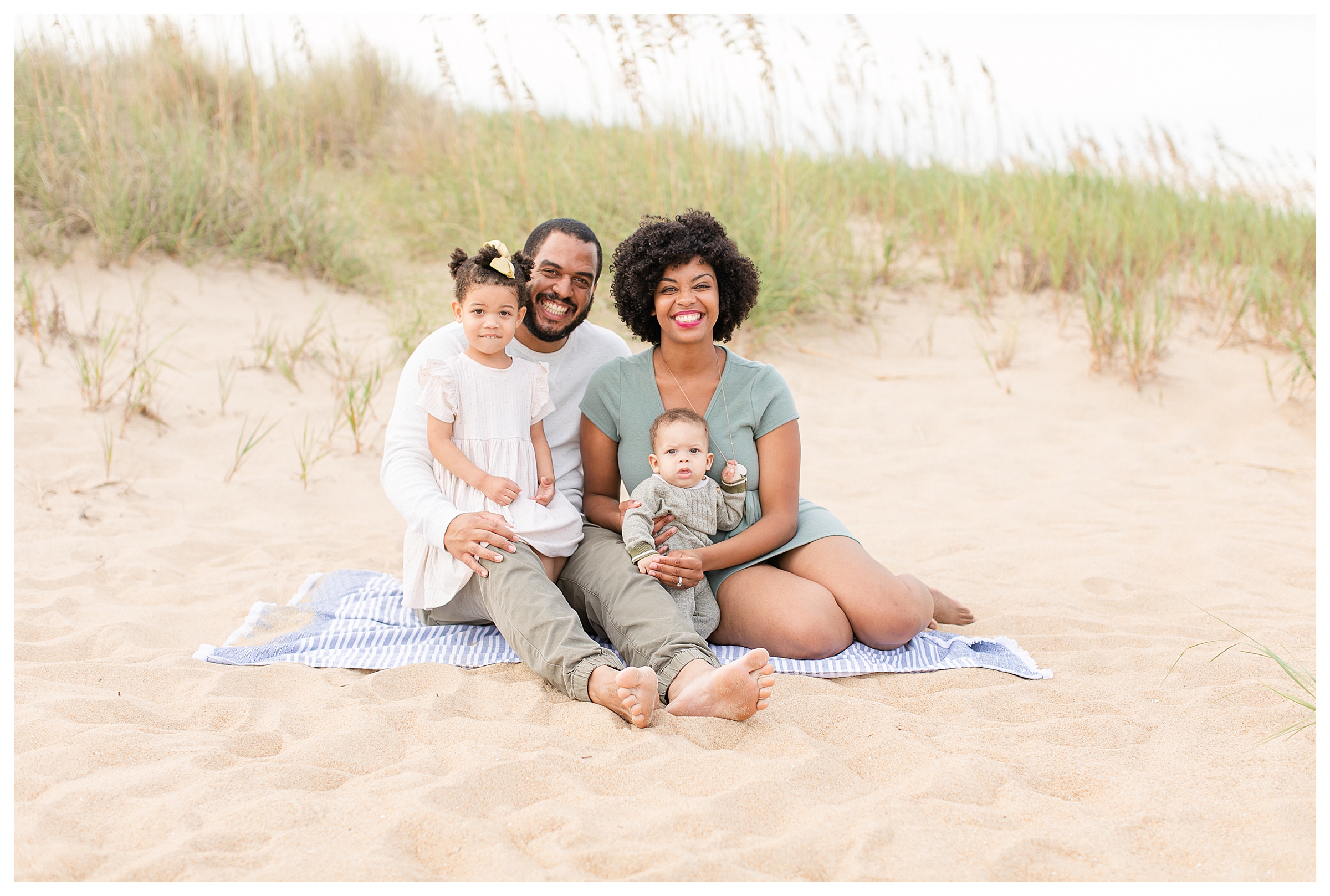 Family of four sitting on the beach for a family portrait